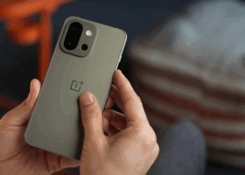 OnePlus 13s review showing compact flagship smartphone design with sleek display and dual-camera setup Photo Credit: YouTube/mobiscrub