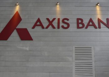 Axis Bank Q1 FY26 earnings report being analyzed by a financial expert on a digital tablet, with stock market charts and investor reaction in the background.