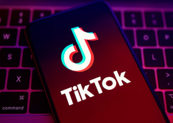 TikTok comeback in India illustration showing glowing TikTok logo on a smartphone with Indian creators filming videos and social media icons in the background.