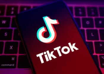 TikTok comeback in India illustration showing glowing TikTok logo on a smartphone with Indian creators filming videos and social media icons in the background.